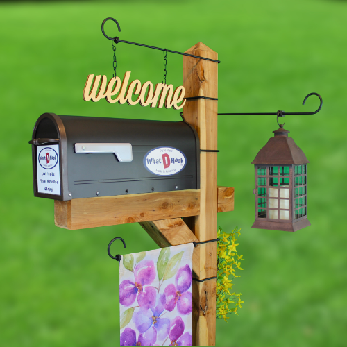 What D Hook garden display hooks holding a lantern, flag and welcome sign all on a mailbox.